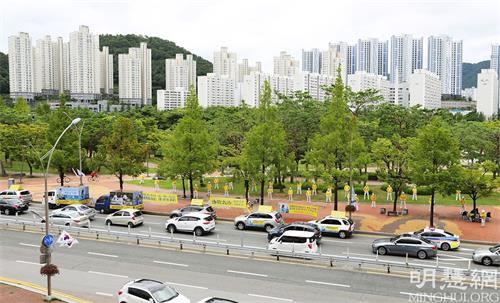 '图1：釜山法轮功学员举办揭露中共对法轮功的迫害以及弘扬法轮大法的车队游行。'