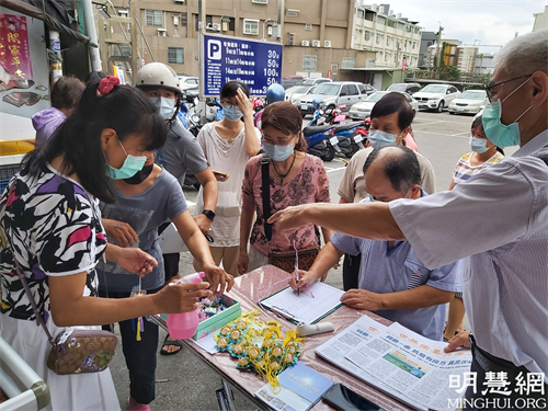 图2-4：法轮功学员在云斗六黄昏市场讲真相发送莲花及真相资料。