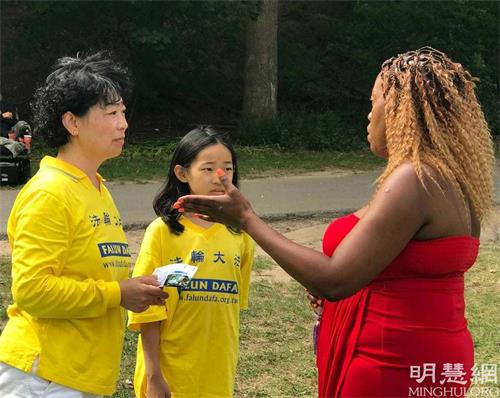'图14:娜藤(Thato)女士在炼功点学完功法后,表示会阅读大法书籍《转法轮》。她说她的名字的意思就是“神的旨意”
