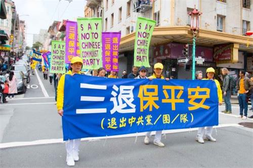 '图：海外法轮功学员游行队伍中呼吁“三退保平安”的横幅'