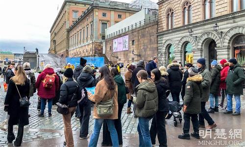 '图1：二零二一年的十二月份，在斯德哥尔摩市中心国会大厦旁的钱币广场，每逢周末两天，法轮功学员都会举办讲<span class='voca' kid='62'>真相</span>活动。'