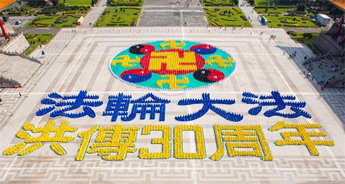 '图1：五千名法轮功学员在台北中正纪念堂自由广场排出殊胜“法轮图形”及“法轮大法洪传30周年”。'