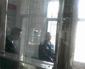 '廖志军（右）在湖南常德津市监狱一监区接见室'