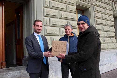'图1：国际人权组织代表费迪尔（右一）和法轮功学员代表莫瑟（右二）将八千份签名递交给瑞士联邦政府，要求制止迫害及中共活摘器官的罪行'