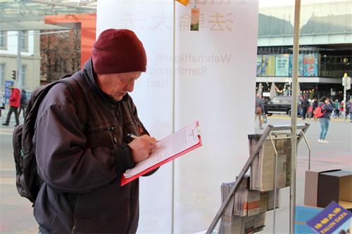 '图3～8：二零二二年十一月五日和二十六日，法轮功学员在伯尔尼（Bern）市中心及火车站传播真相和征签，过往行人签名支持制止中共罪行。'