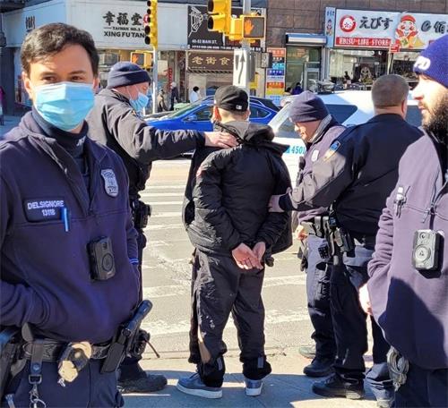 '图1：二月十五日中午时分，纽约市警109分局的警察在法拉盛缅街与凯辛娜大道的交界处，拘捕了近日来，多次暴力袭击法轮功多个真相点的疑犯。（法轮功学员提供）'