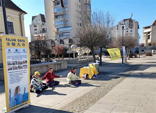 图1-2：二零二二年三月十一日和十二日，法轮大法学员在特尔古穆列什（Târgu Mureş）市中心的玫瑰广场向人们介绍法轮功。图中的法轮功学员正在演示法轮功的第五套功法。