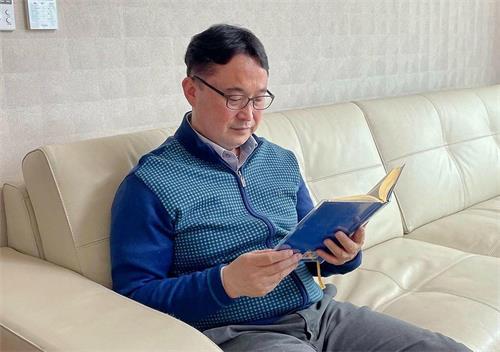 图:玄润炅正在阅读《转法轮》
