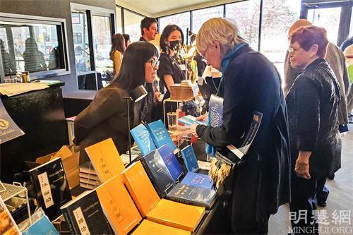 图1：观众在内华达州雷诺先锋艺术中心大厅内的神韵礼品柜台购买法轮大法书籍。（明慧网）
