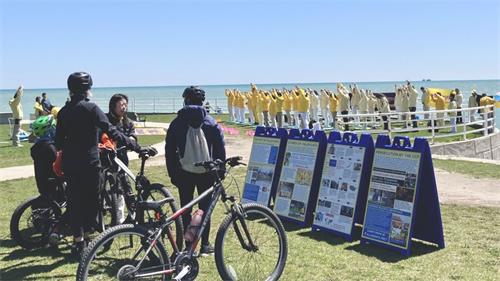 '图4-5：二零二二年五月七日，大芝加哥地区部分法轮功学员在密西根湖畔集体炼功，民众主动前来了解法轮功。'