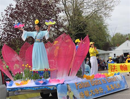 图1：二零一八年密西根州法轮功学员参加郁金香节游行，安妮（蓝色衣服）站在花车上