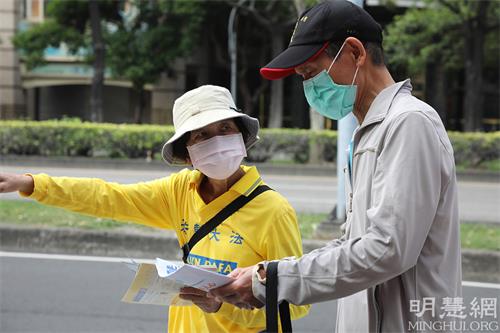 图4：法轮功学员派发资料给过往民众。