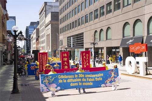 图7-9：2022年5月10日，来自加拿大东部部分法轮功学员汇聚在首都渥太华国会山前，庆祝法轮大法洪传三十周年。图为法轮功学员在市中心步行街遊行。