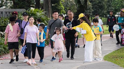 '图9:个别法轮功学员也向民众讲真相、做征签。'