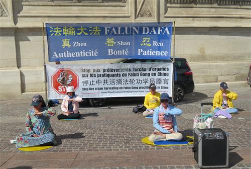 图1：二零二二年六月十一日， 法轮功学员在巴黎市中心的夏特蕾街区演示法轮功功法。