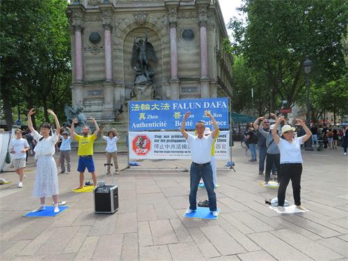 图4：二零二二年六月十九日，法轮功学员在巴黎圣米歇尔广场（Place Saint-Michel）演示法轮功功法。