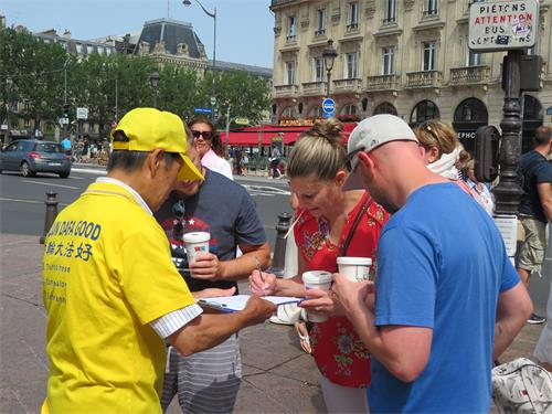 图5～8：二零二二年六月十九日，在巴黎圣米歇尔广场（Place Saint-Michel），游人签字支持法轮功学员反迫害。