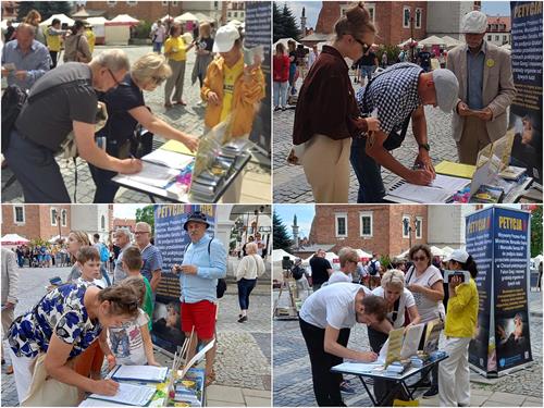 图1～2：二零二二年七月九日，法轮功学员来到位于波兰东南部的历史名城——桑多梅日（Sandomierz），举办信息日活动，向当地市民及游客传播法轮功的真相，并征签。在了解真相后，许多人纷纷在征签表上签名。