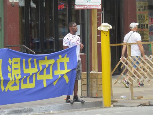 图7：非裔男青年哈利奥（Khalio）自愿拉横幅来支持法轮功学员。