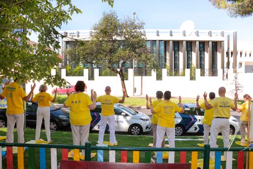 '图6～9：西班牙法轮功学员中使馆前举办反迫害二十三年集会。图中学员在演示法轮功功法。'