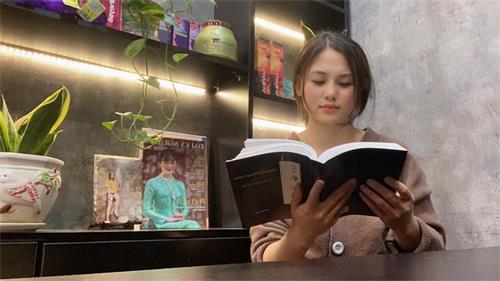 图1:越南河内的美发店老板陈宝贷(Bao Loan)女士在看越南文版《转法轮》