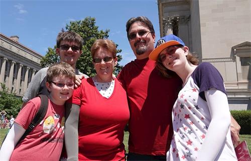 '图9：来自亚利桑那州的教师詹妮。麦奎尔　（Jennie Mccquire，中，穿红色上衣的女士）和先生带着三个孩子观看游行。'