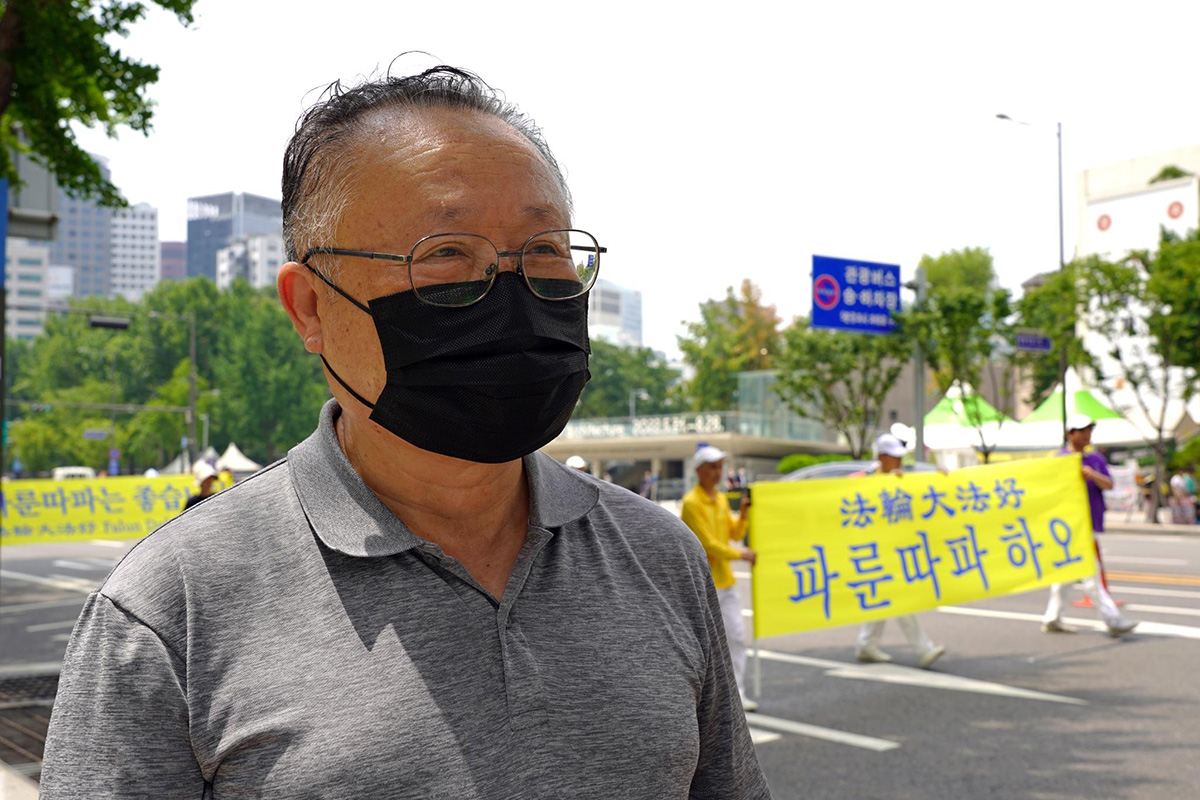 图22：在街头观看法轮功游行队伍的首尔市民金在正先生支持反迫害，并希望法轮功广传世界。