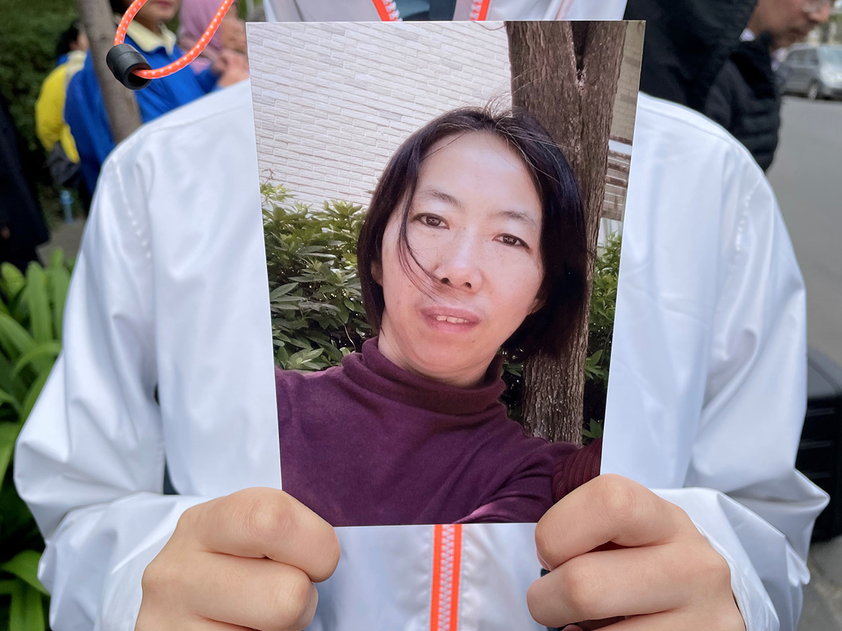 图4：二零二二年八月十五日，姜永芹的大女儿在新闻发布会上手持母亲照片。