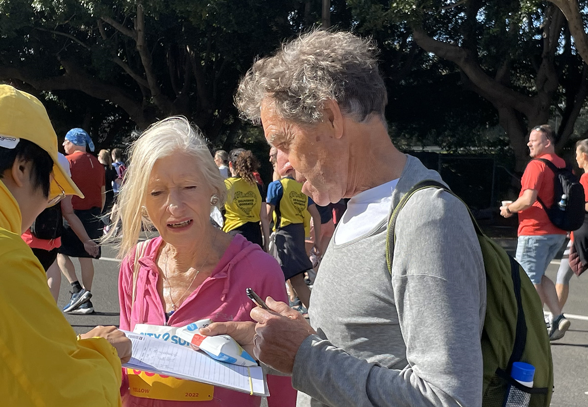 图14：当地运动员苏珊（Susan）和她的丈夫布赖恩（Bryan）正在签名支持法轮功反迫害