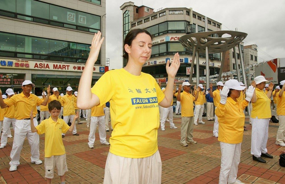 '圖5：艾瑪和賈洛德在韓國工作期間，全家參加當地的反迫害活動。艾瑪身後是他們的兒子。'