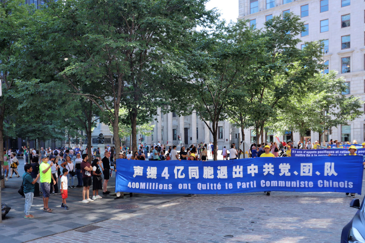 图3：2022年8月6日，蒙特利尔游行庆祝四亿中国人退出中共党、团、队组织。图为游行队伍经过游人众多的蒙特利尔老城兵器广场。