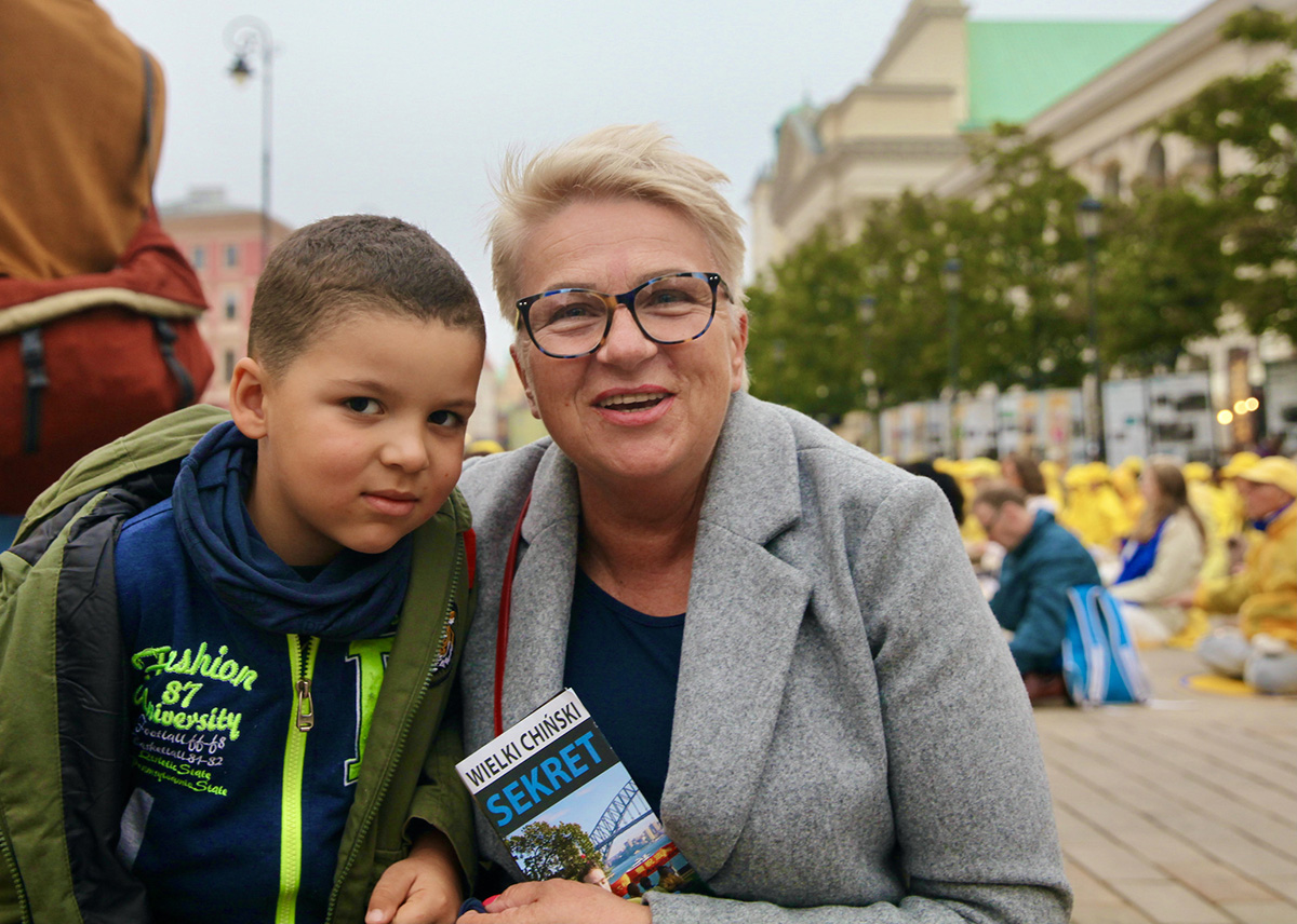 图12：玛兹扎克女士（Katarzyna Marczak）从网上得知烛光悼念活动，特意带着外孙赶到活动地点，为她自己和女儿签名声援法轮功学员反迫害。
