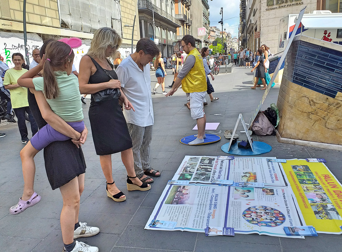图4～6：二零二二年八月二十七日，法轮功学员在那不勒斯市中心举办讲真相活动，吸引不少过往路人的注意，有的停下来阅读真相展板，有的与学员交谈。