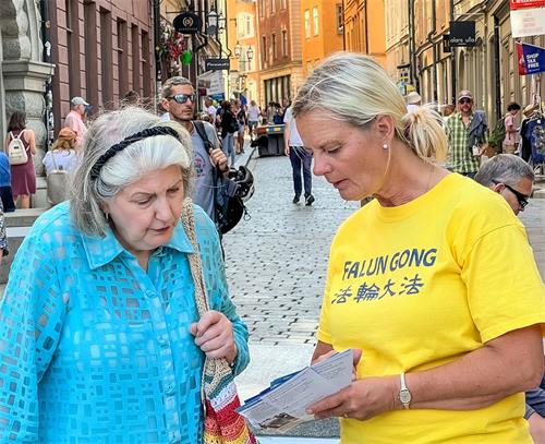 '图2：二零二二年七月二十日，卡特琳在斯德哥尔摩参加法轮功和平反迫害二十三周年的活动中，向瑞典民众面对面讲真相。'