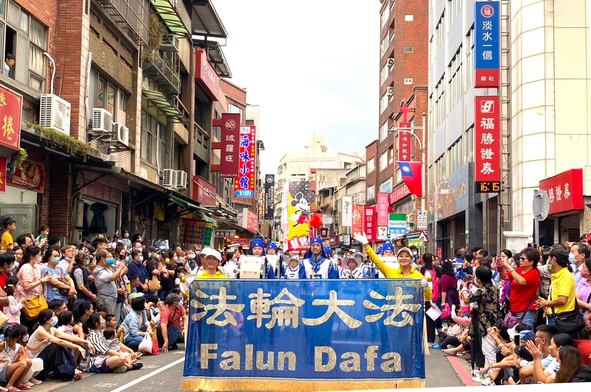 图1：二零二三年十月十四日，法轮功学员组成的天国乐团参加了台湾新北市的“淡水环境艺术节”踩街活动，受到两旁观众的欢迎。