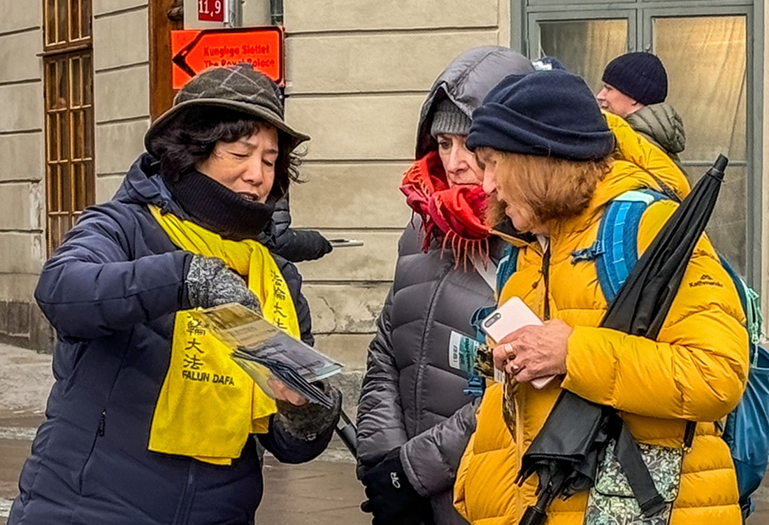 图4～5：十月二十七日下午天气寒冷，在斯德哥尔摩皇宫旁法轮功学员讲真相的活动现场前来了解真相的路人络绎不绝。法轮功学员面对面向人们讲真相。