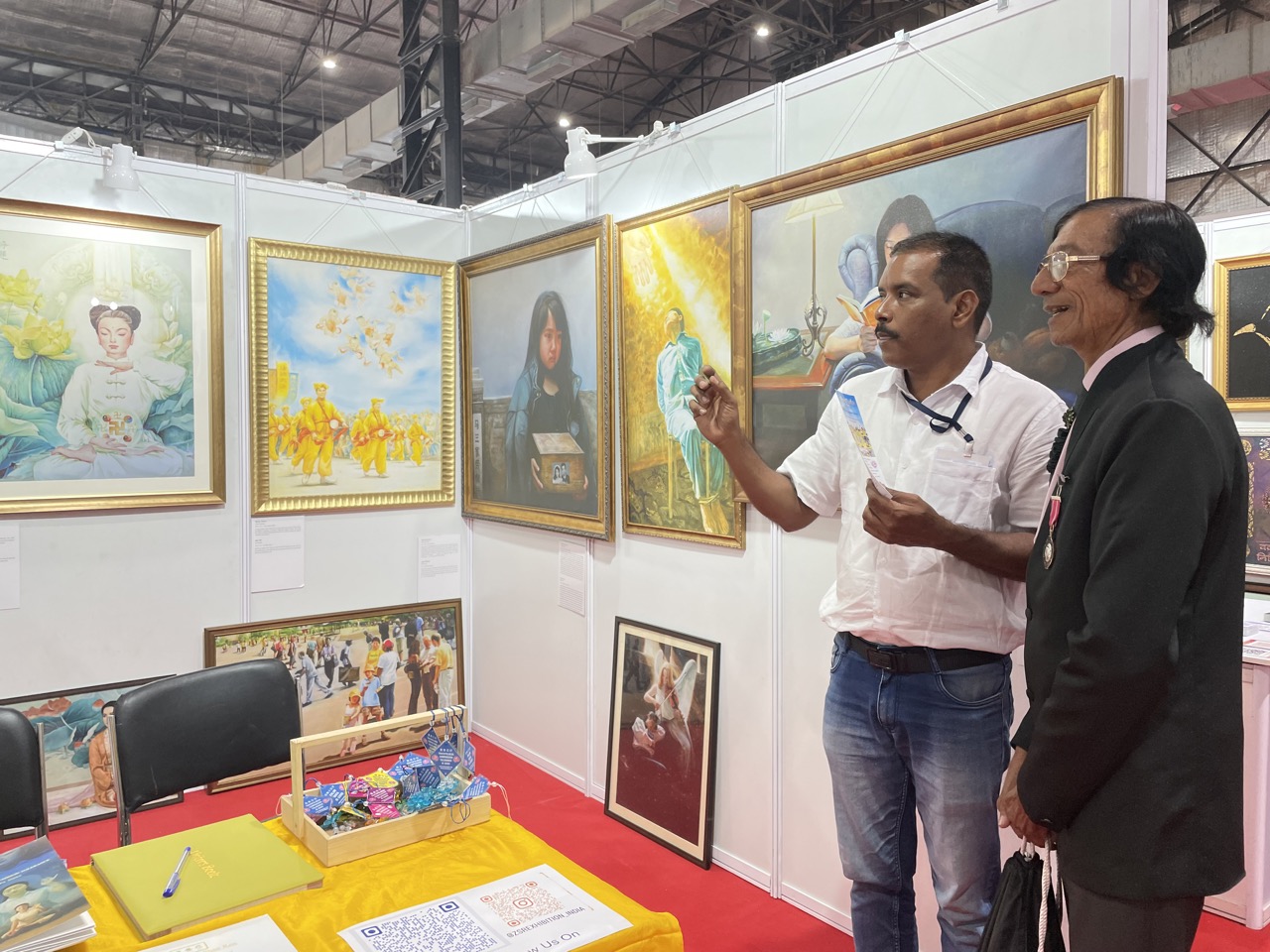 图5：莲花士奖得主普莱姆吉特·巴里亚（Premjit Baria，右）在欣赏真善忍美展的画作。
