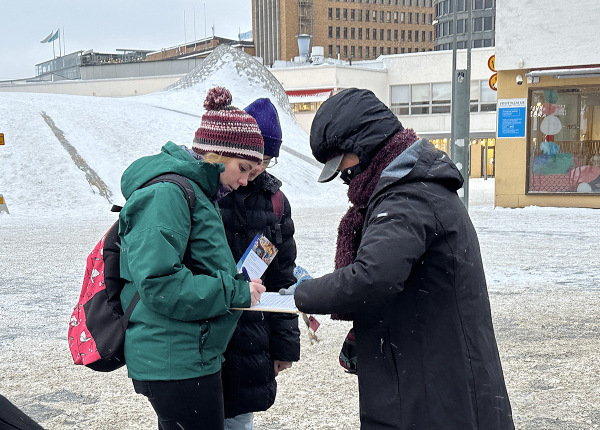 Kuva 5: Ohikulkijat allekirjoittivat allekirjoitukset tukeakseen Falun Gongin harjoittajien taistelua vainoa vastaan.