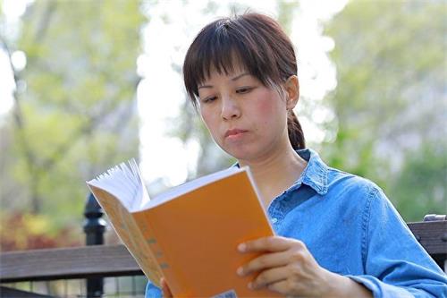 '图5：法轮功学员刘庆在读《转法轮》。'