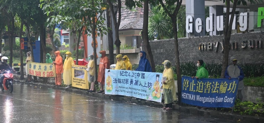 图2：大雨中，法轮功学员在泗水中国领事馆前举行和平抗议活动