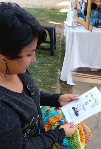 '图3：用钩针编织的手工艺人约翰娜·赫维亚（Johanna Hevia）在阅读法轮大法传单。'