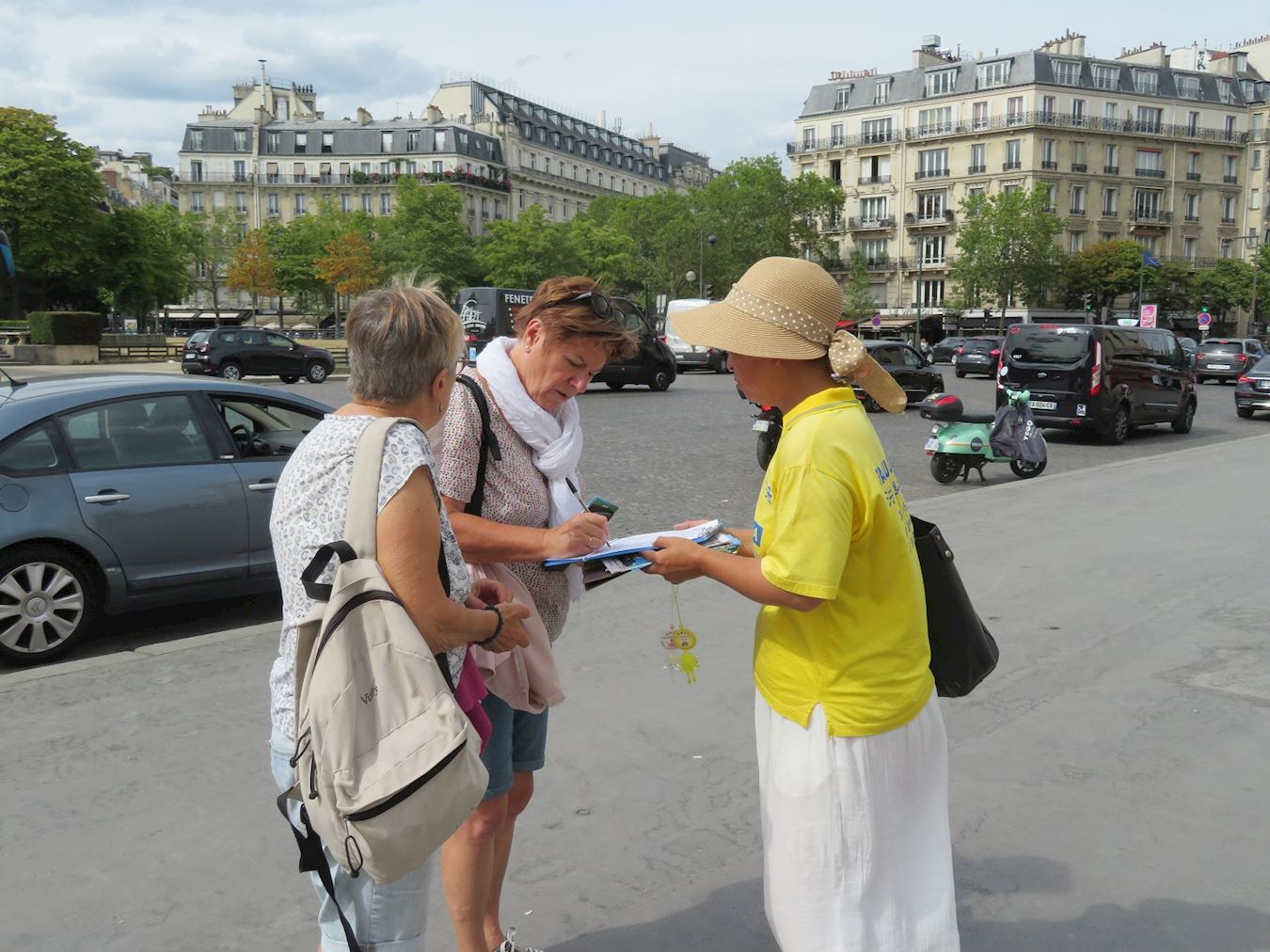'图7～8：法轮功学员在巴黎人权广场集会，宁静祥和的炼功场面，吸引市民及游客驻足观看，有的主动接过真相资料阅读，有的民众在请愿书上签名支持。'