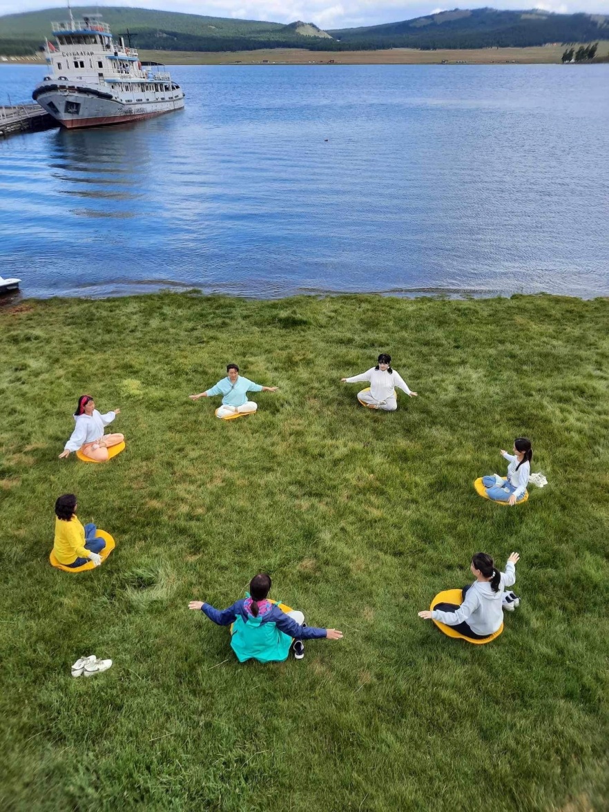 图4：忙碌一天的学员在宁静的湖边打坐炼功