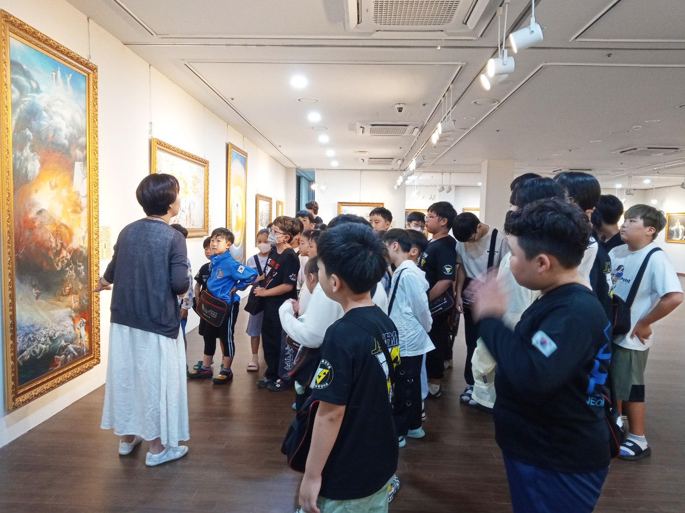 图4：认真听真善忍美展作品说明的补习班学生们。