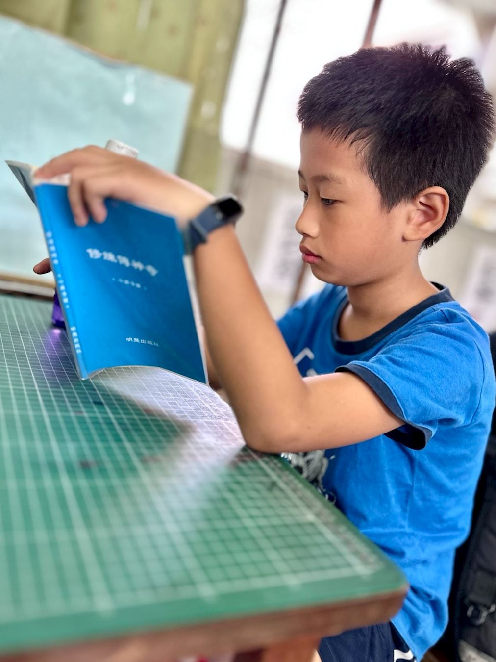 '图3：台湾学生小毅阅读明慧儿童故事集《修炼传神奇》'
