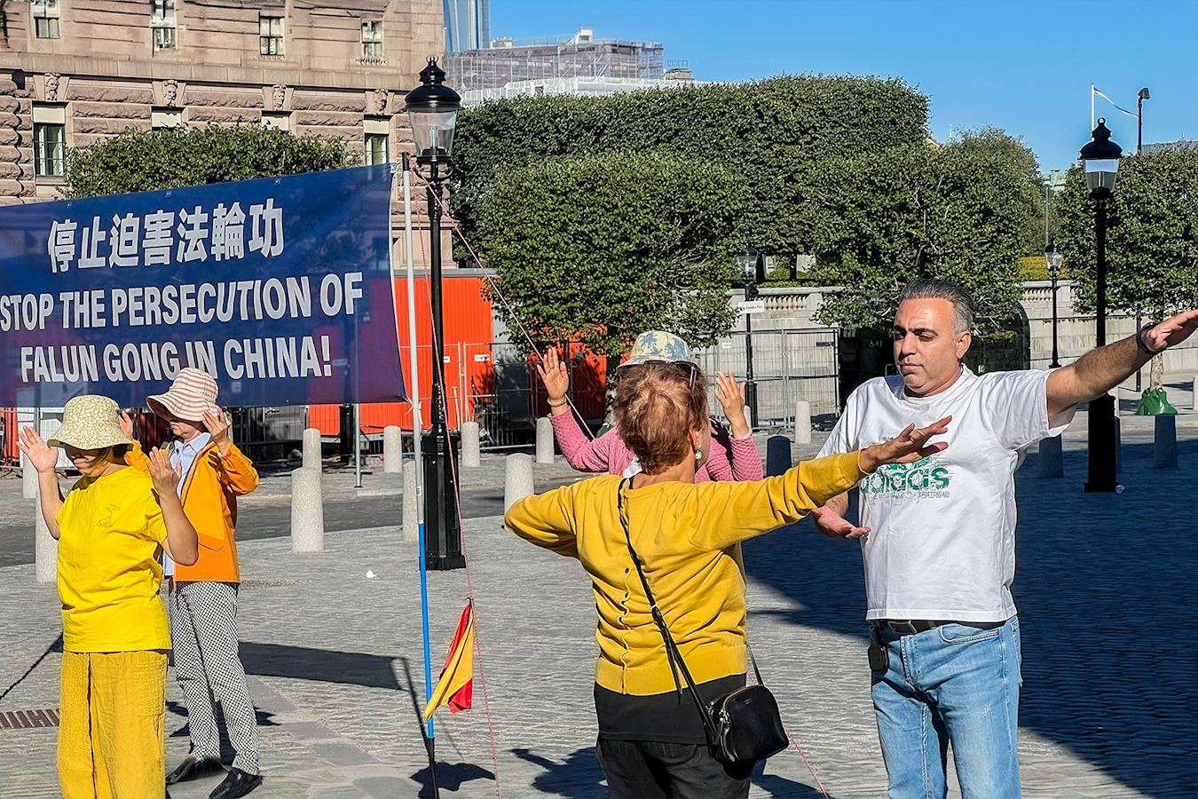 '图12:许多人明真相后表示对中国古老的传统文化特别感兴趣,很想学炼法轮功,回去就去找当地的炼功点学功,有的当场就学炼功动作。'