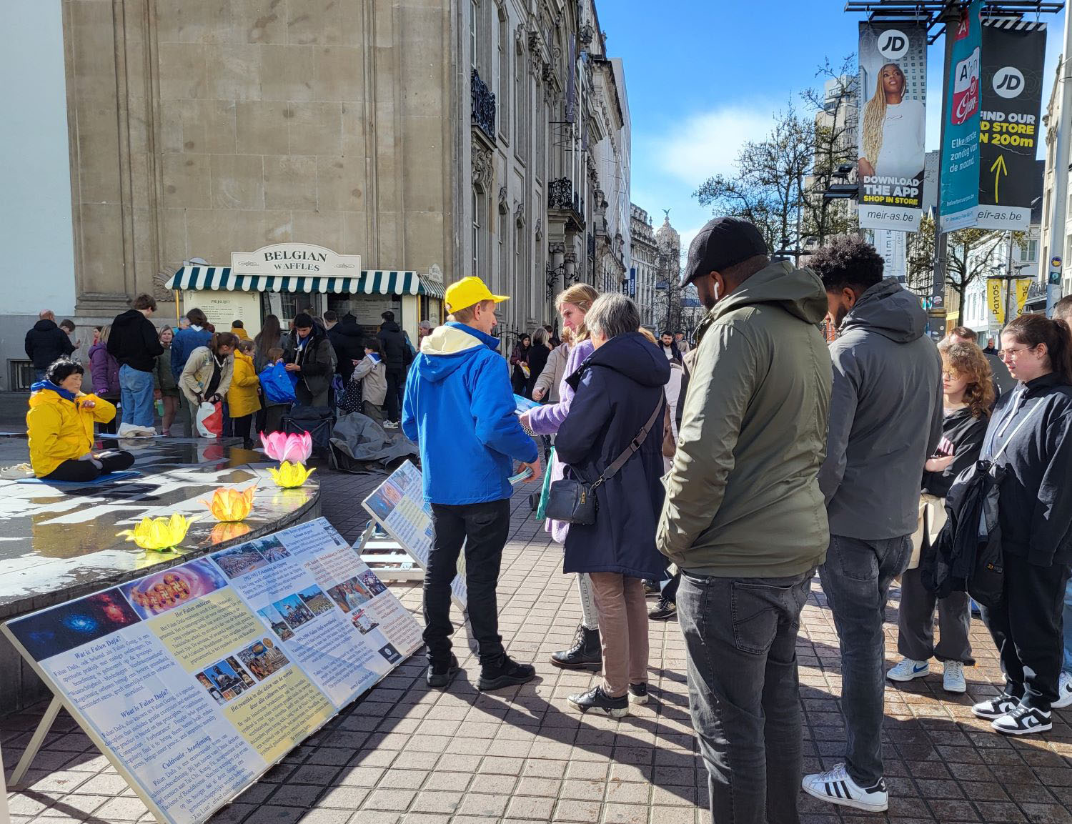 图1～2：二零二四年三月二十三日，法轮功学员在安特卫普（Antwerpen）商业街举办弘法讲真相活动。学员在向市民及游客展示功法。