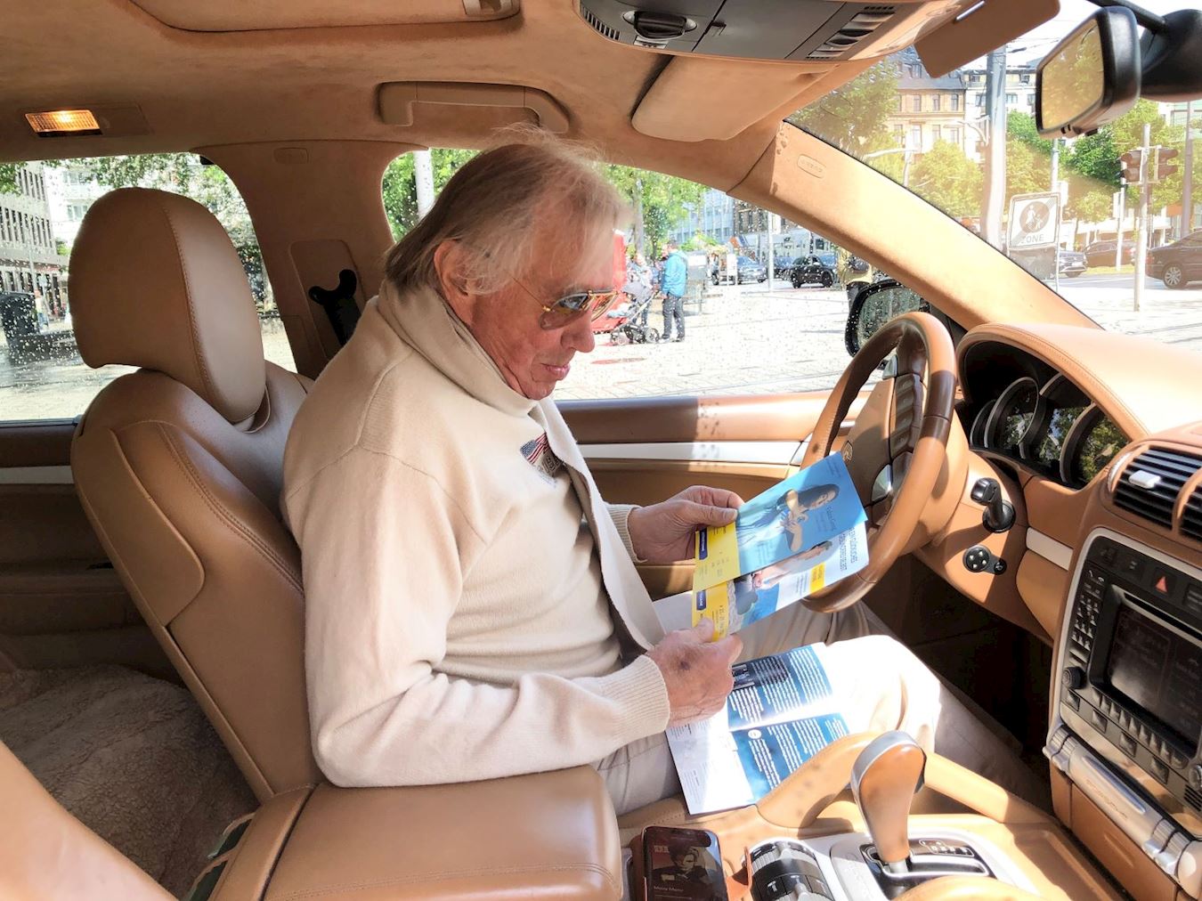 '图9：车主坐在车里认真阅读曼海姆免费教功的传单。'