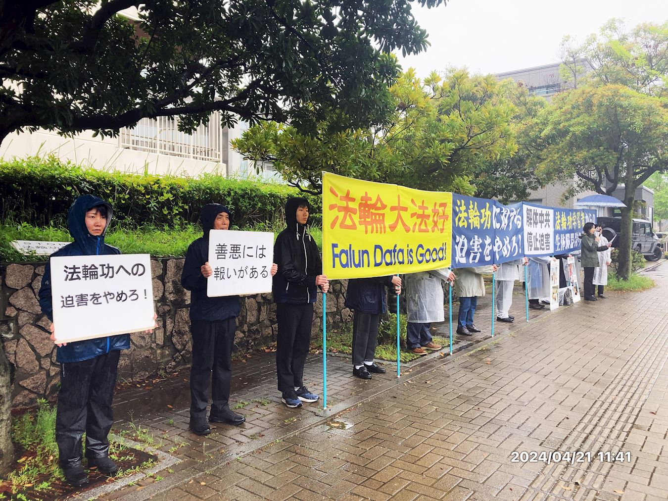 '图1：二零二四年四月二十一日，熊本地区的法轮功学员在位于日本九州的福冈和长崎的中领馆前，在大雨中坚持举行纪念四・二五上访二十五周年集会。'