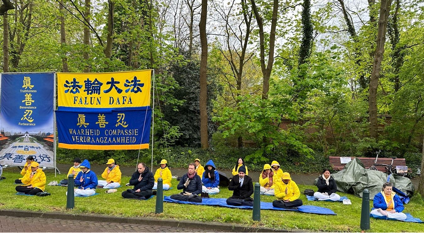 '图1～2：荷兰法轮功学员及来自墨西哥、加拿大和阿鲁巴岛的学员在海牙中国驻荷兰大使馆对面的街道举行集会'